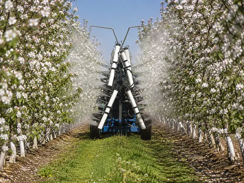 Supplemental pollen being applied in a commercial fruit orchard